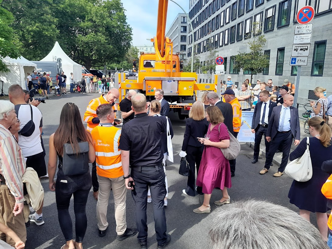 Minister of Transportation in front of a crane lift that can be ridden